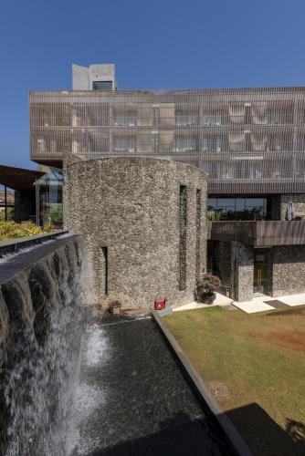 a stone building with a waterfall in front of a building at Radisson Resort and Spa Lonavala in Lonavala