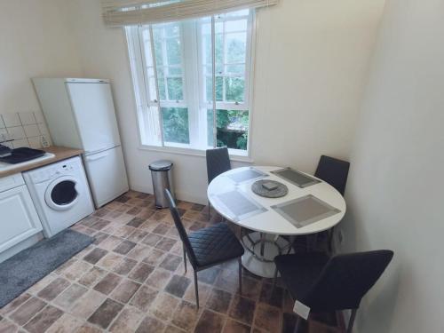 a kitchen with a table and chairs in a room at Luxe & Stylish Centralised Watford Apt - Fast Wi-Fi & Free Parking Near Harry Potter Studios Tour in Watford