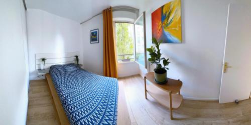 a bedroom with a blue bed and a window at uta house la plaine in Saint-Denis