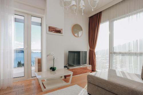 a living room with a couch and a tv at Lux Apartments Sunrior in Budva