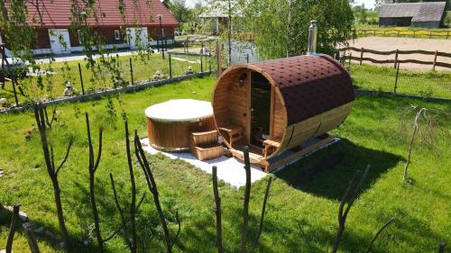 ein kleines Baumhaus mit einem Tisch im Gras in der Unterkunft Harasimówka in Dąbrowa Grodzieńska-Wieś