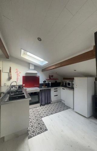 a kitchen with a sink and a stove top oven at Appartement mansardé et climatisé 50 m2 in Pompignan