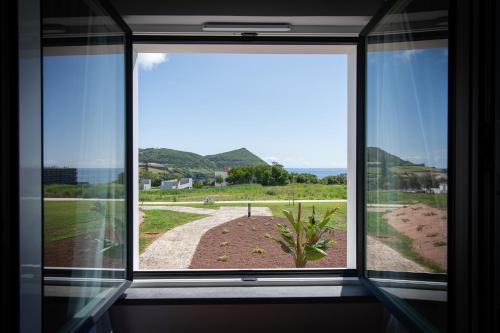 a window in a room with a view of the ocean at Palacio Santa Catarina Hotel in Angra do Heroísmo