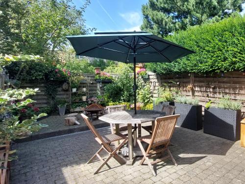 a table and chairs with an umbrella on a patio at Room "Carpe Diem" in Zele