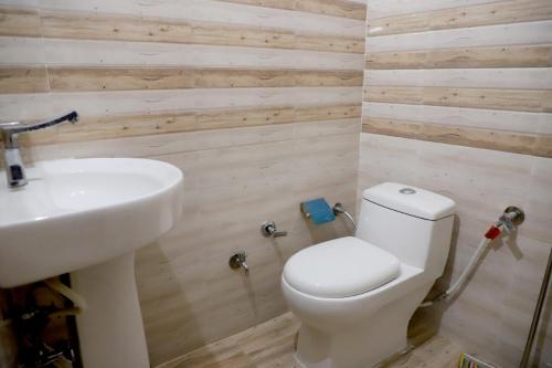 Rk Lodge في أمريتسار: حمام به مرحاض أبيض ومغسلة