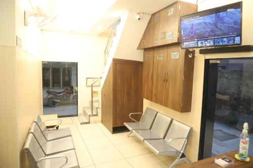 a living room with chairs and a tv on a wall at Rk Lodge in Amritsar