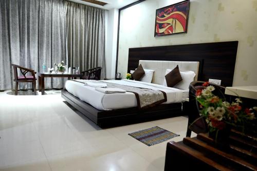 ein Schlafzimmer mit einem großen Bett und einem Tisch mit einem Tisch in der Unterkunft Hotel Badrika Inn in Rewa