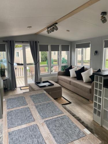 sala de estar con sofá y mesa en Kingfisher Quay Lodge en Clacton-on-Sea