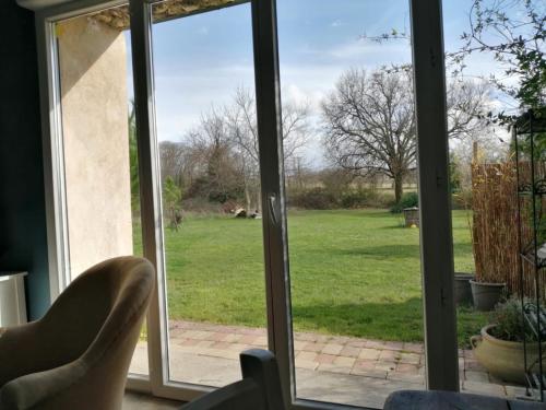 a sliding glass door with a view of a yard at La Place des Amis in Saint-Gervais