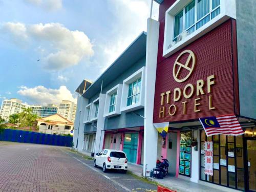un hotel con un coche blanco aparcado delante de él en TT Dorf Hotel Taiping, en Taiping