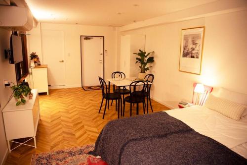 a room with a bed and a table and chairs at #5 3stops to Shinjuku station stylish spacious studio apartment in Tokyo