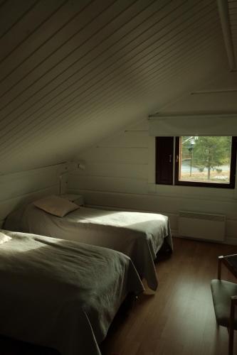 two beds in a room with a window at Jaloilevi - Kätkänrinne in Kittilä