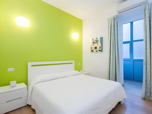 a bedroom with a white bed and a green wall at The Apartment at Spanish Steps in Rome