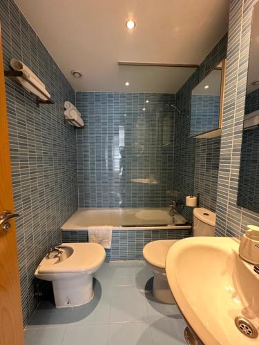 a bathroom with two sinks and a tub and a toilet at AT home Señorio de Molina in Guadalajara