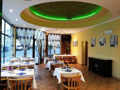 a restaurant with tables and chairs and a green ceiling at Plaza Real by Atlantichotels in Portimão