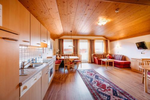 eine Küche und ein Wohnzimmer mit einem Sofa und einem Tisch in der Unterkunft Hotel Taxerhof in Radstadt