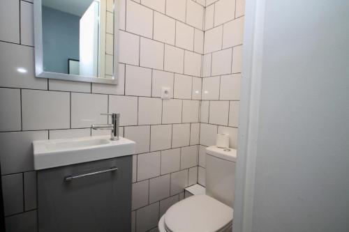 uma casa de banho com um WC, um lavatório e um espelho. em 02 Chambre avec lit double et sdb privé Wifi em Saint-Denis