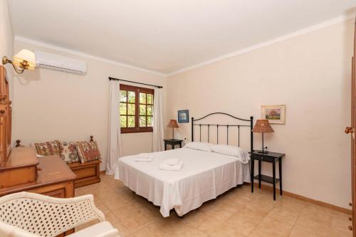 1 dormitorio con cama blanca y sofá en Villa Can Jaume, en Pollensa