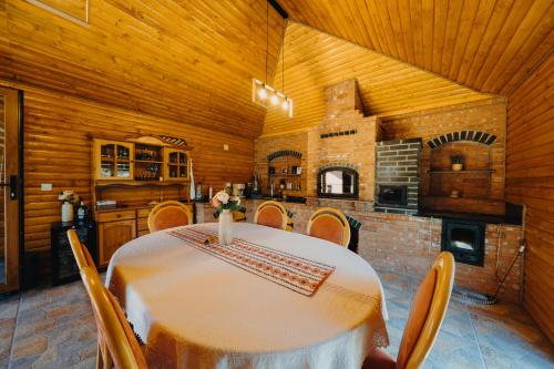 una sala da pranzo con tavolo e una cucina di Casa Diana a Vatra Dornei