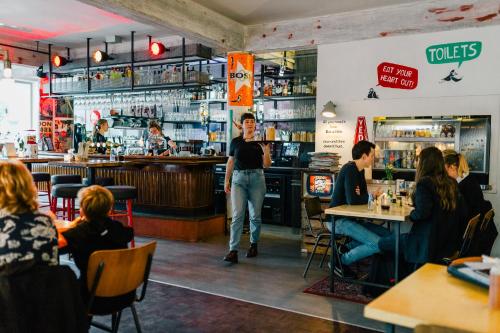 a man standing in a restaurant with people sitting at tables at Hotel Credible in Nijmegen