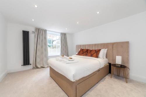 a bedroom with a large bed and a window at Bright King's Cross 2 bedroom flat with patio in London