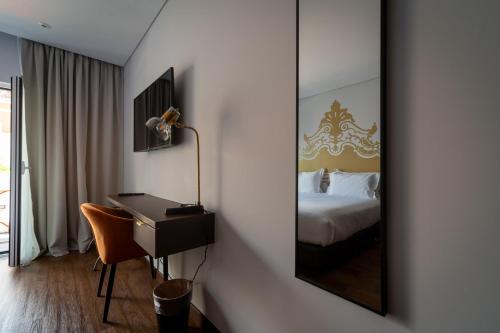 a bedroom with a mirror and a desk and a bed at Palacio Santa Catarina Hotel in Angra do Heroísmo