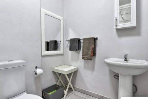uma casa de banho branca com um lavatório e um WC em Sea la Vie 12 Bridge em St Lucia