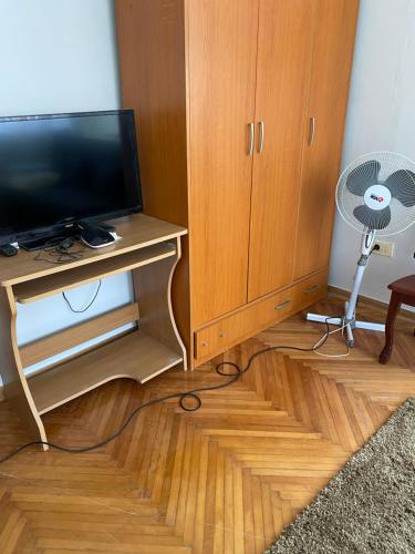a room with a tv and a cabinet and a fan at Apartman NB in Sarajevo