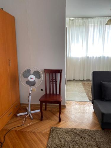 a living room with a chair and a fan at Apartman NB in Sarajevo