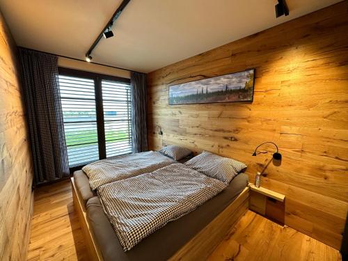 a bedroom with a bed in a wooden wall at BARTH Holiday - Říčky v Orlických horách in Říčky