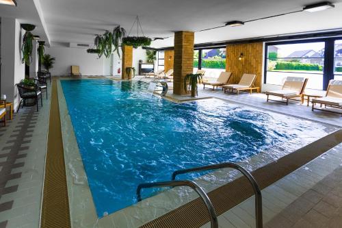 a large pool with blue water in a building at Hotel Westermann in Oelde