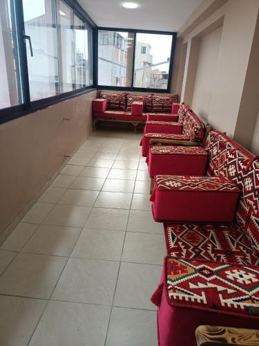 a row of red couches in a room with windows at Fetih Suite Home A3 in Istanbul