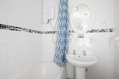 a white bathroom with a sink and a mirror at Free Parking Good location With Garden in Taunton