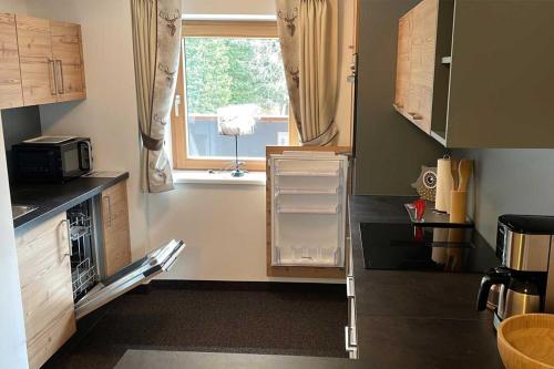 eine kleine Küche mit einem Fenster und einer Mikrowelle in der Unterkunft Wohnung Kreuzjoch 142- Naviser Huette in Navis