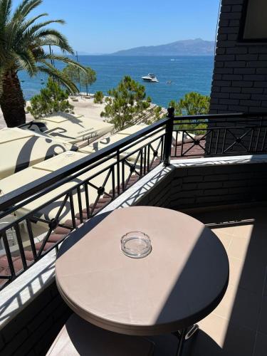 a table on a balcony with a view of the ocean at Hotel Summer in Sarandë