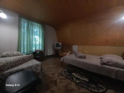 ein Hotelzimmer mit zwei Betten und einem Fenster in der Unterkunft Готель Загадка, Умань in Gorodnitsa