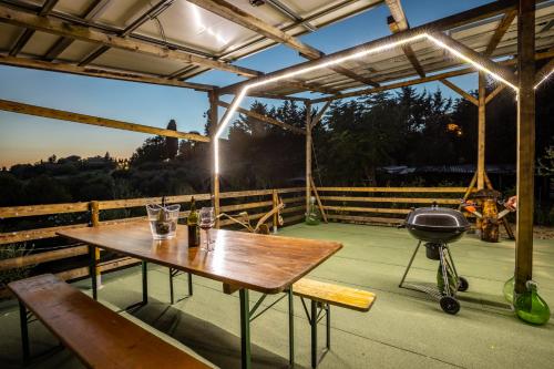 a picnic table and a grill on a patio at Sole Verde green house in Terricciola