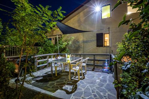 a table and chairs on a patio at night at Sole Verde green house in Terricciola