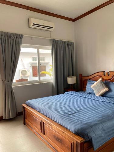 a bedroom with a bed with blue sheets and a window at Lotus Haven Villa in Siem Reap