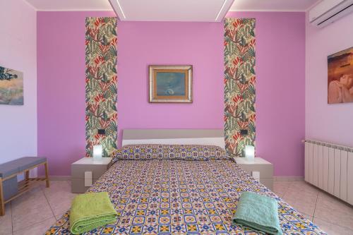 um quarto com uma cama com paredes roxas em A Casa Mia em Floridia
