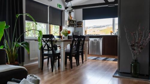 a kitchen and dining room with a table and chairs at Kamburinn Cottage in Hveragerði