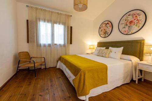 a bedroom with a bed with a yellow blanket on it at Apartamentos Rurales la Campiña in Casiñas Bajas