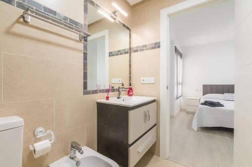 a bathroom with a sink and a mirror and a bed at La Caracola - Espíritu libre A/A in El Altet