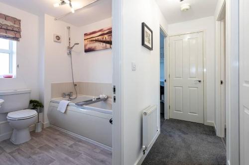 uma casa de banho com uma banheira, um WC e um lavatório. em Beautifully designed 3 Bed House - in Manchester em Manchester