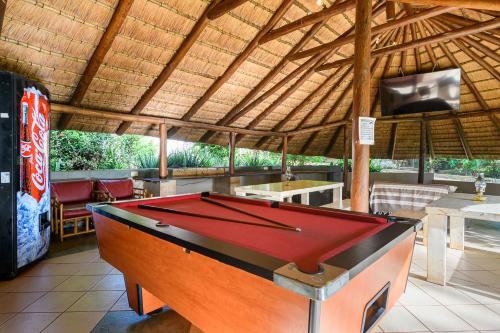 a pool table in a pavilion with a tv at Country Rose in Hluhluwe