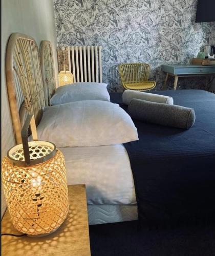 een slaapkamer met 2 bedden met kussens en een tafel bij Logis Hôtel Chalet Altitude in Pierre-Percée