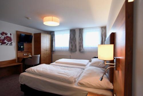 a hotel room with two beds and a lamp at Hotel-Restaurant am Hochfuchs in Eugendorf