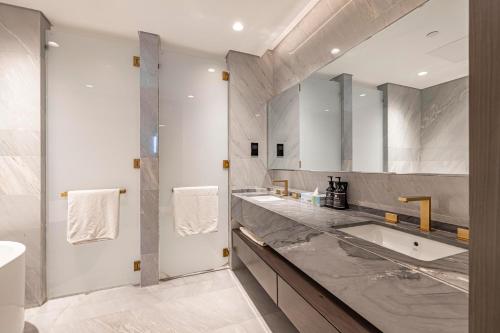 a bathroom with two sinks and a large mirror at Five Palm Hotel and Residence - Platinium Dubai in Dubai