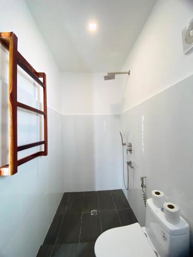 a white bathroom with a toilet and a window at Island World Panglao in Panglao