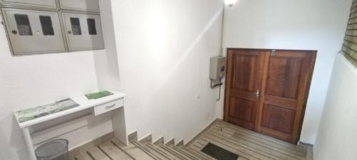 a small bathroom with a wooden cabinet and a sink at Hostel Center Luxury in Sarajevo